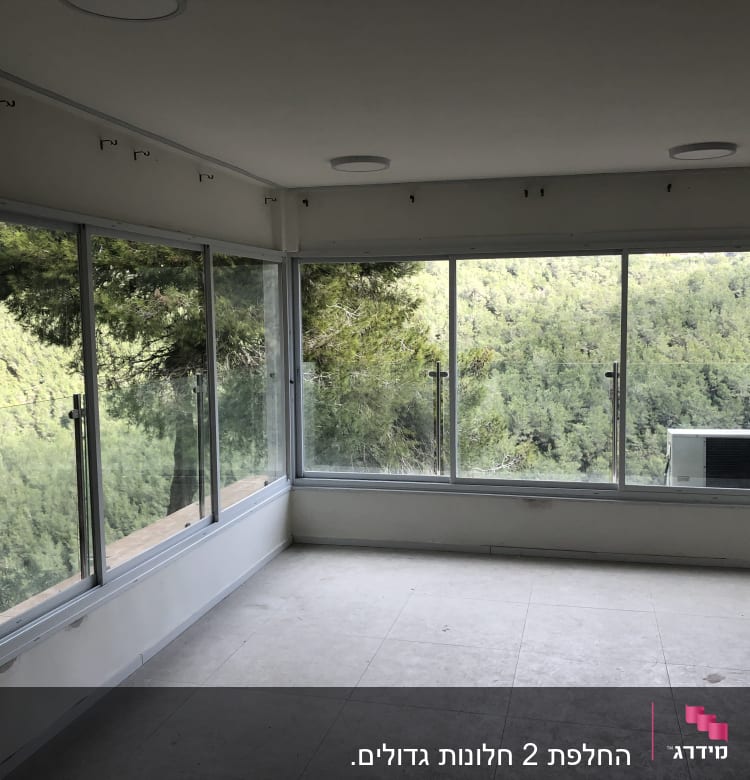 חלונות אלומיניום גדולים עם נוף ליער ירוק